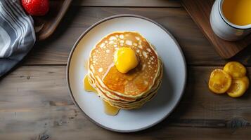 Breakfast table setting with a stack of buttermilk pancakes on one plate, meal photography photo
