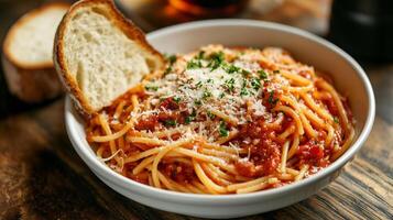Dish of spaghetti with marinara sauce and grated cheese, served with a slice of bread, food setting photo