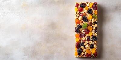 Fruit and nut bar with dried fruits and nuts on a flat surface, food setting photo