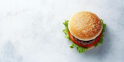Assembled small burger with patty, lying flat on a simple background, food setting photo