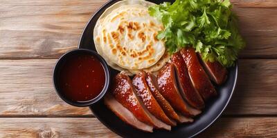 Peking duck with dipping sauce and pancakes, food setting photo