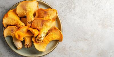 Whole chanterelle mushrooms placed in a row on a serving platter, food setting photo