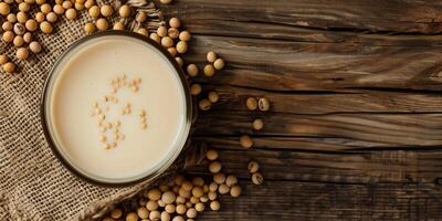 Glass of soy milk with soybeans scattered on rustic wooden surface, food photography photo