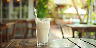 Glass with a straw filled with a yogurt drink, placed on a wooden dining table, food photography photo
