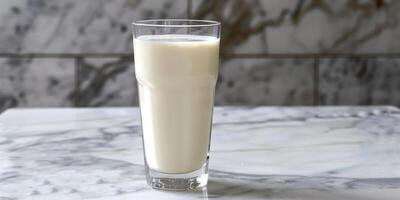 Glass of probiotic yogurt drink with an even consistency, placed on a marble table, gastronomy photography photo