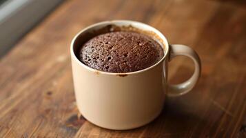 Mug cake in a simple mug with a smooth, even surface on a plain table, photorealistic food photo