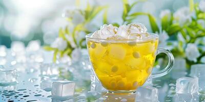 Transparent cup of yellow tea with floating white tapioca pearls and ice cubes, gastronomy photography photo
