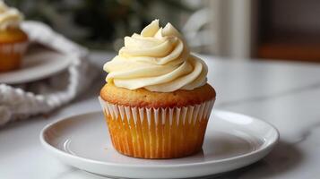 Cupcake with frosting, positioned in the center of a plain white plate, food setting photo