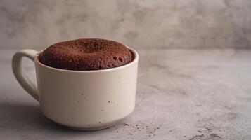 Mug cake in a simple mug with a smooth, even surface on a plain table, food setting photo
