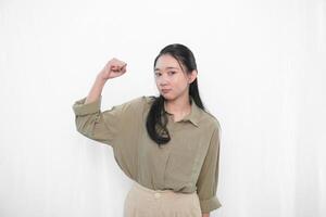 The smiling expression of an Indonesian Asian woman wearing a green dress and making a symbol of enthusiasm photo