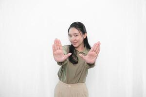 The smiling expression of an Indonesian Asian woman in green and making a stop symbol photo