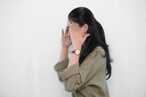 The expression of an Indonesian Asian woman in green is that she has a headache or is confused. photo