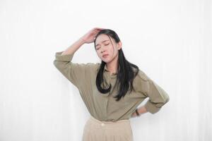 The expression of an Indonesian Asian woman in green is that she has a headache or is confused. photo