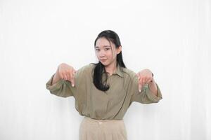 The smiling expression of an Indonesian Asian woman in green and pointing down photo