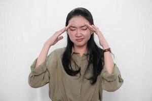 The expression of an Indonesian Asian woman in green is that she has a headache or is confused. photo