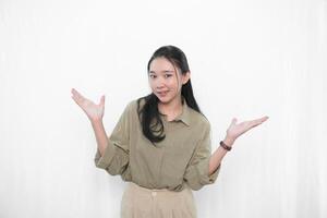 The smiling expression of an Indonesian Asian woman in green and raising both hands to the side photo