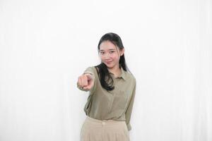 The expression of a smiling and pointing forward Indonesian Asian woman in green clothes from photo