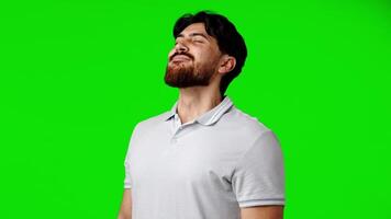 Man with beard enjoying a moment of relaxation in front of a bright green background video