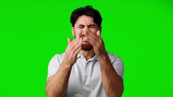 Man expresses strong emotions with comedic intensity in vibrant green background setting video