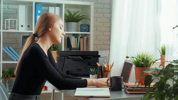 Young woman working at modern desk in bright office space, enjoying peaceful atmosphere while focusing on her tasks video