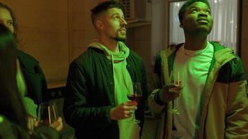 Friends enjoying drinks together at a lively gathering in an urban setting during the evening hours video