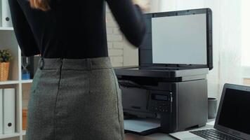 A woman prepares to print important documents in a modern office setting during the afternoon hours video