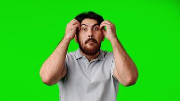 Man expresses shock and disbelief while standing in front of a green background video