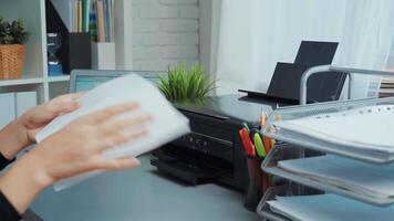 Organizing documents and workspace at home office in modern setting with laptop and printer during the afternoon video