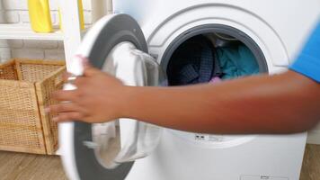 Loading Clothes Into A White Washing Machine In A Laundry Room video