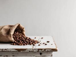 Cocoa beans spilling from a burlap sack on a rustic wooden table. photo