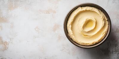 Close-up of hummus in a wide bowl with a smooth, undisturbed surface, photorealistic food photo