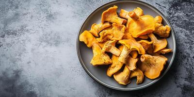 Chanterelle mushrooms placed in a small pile on a serving platter, food setting photo