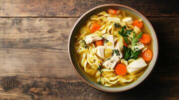 Chicken noodle soup in a shallow bowl with submerged ingredients, meal photography photo