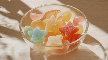 Clear bowl with various candy shapes, including stars and moons, on a plain surface, meal photography photo