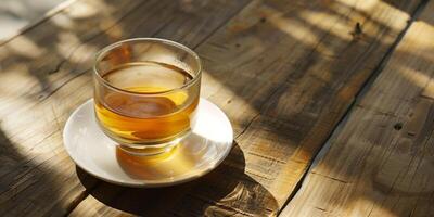 Clear glass of unsweetened herbal tea, placed on a white saucer on a wooden surface, meal photography photo