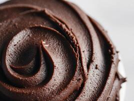 close up image of dark brown chocolate frosting with rough textured surface. photo