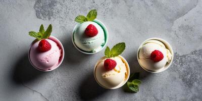 Colorful scoops of ice cream with fresh raspberries and mint on a textured gray surface. photo