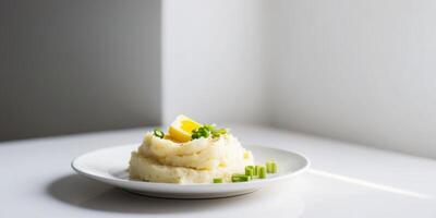 Classic mashed potatoes topped with butter and green onion. photo