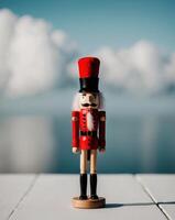A wooden nutcracker with a red hat stands in front of a blue background. photo