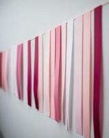 A row of paper with different colors and shades of pink. photo
