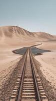 Train tracks stretch across a peaceful, arid landscape under clear skies Vertical Mobile Wallpaper photo
