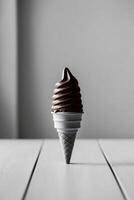 Chocolate ice cream cone is sitting on a table. photo
