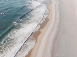 Aerial View of Waves Crashing on a Sandy Shore. photo