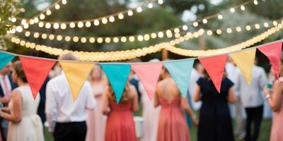 Colorful bunting is swaying in the breeze as string lights illuminate a festive backyard gathering. photo