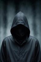 A hooded criminal or hacker is depicted with a dark silhouette in an ominous and faceless portrayal. photo