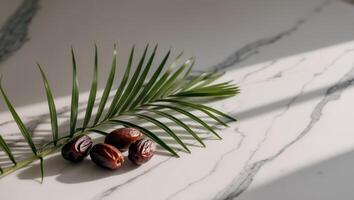 Dates and Palm Leaves on a Marble Background. photo
