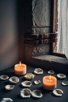 White roses lying near two burning candles on a dark background with shadows cast by a window. photo