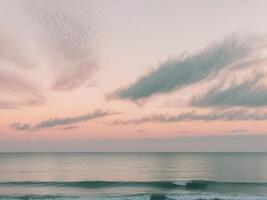 Pastel sunset sky with wispy clouds over calm ocean. photo