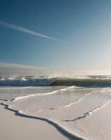White Foamy Waves Crashing on a Sandy Beach Under a Blue Sky. photo