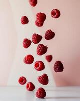 Various falling fresh ripe raspberries on light pink background horizontal composition. photo